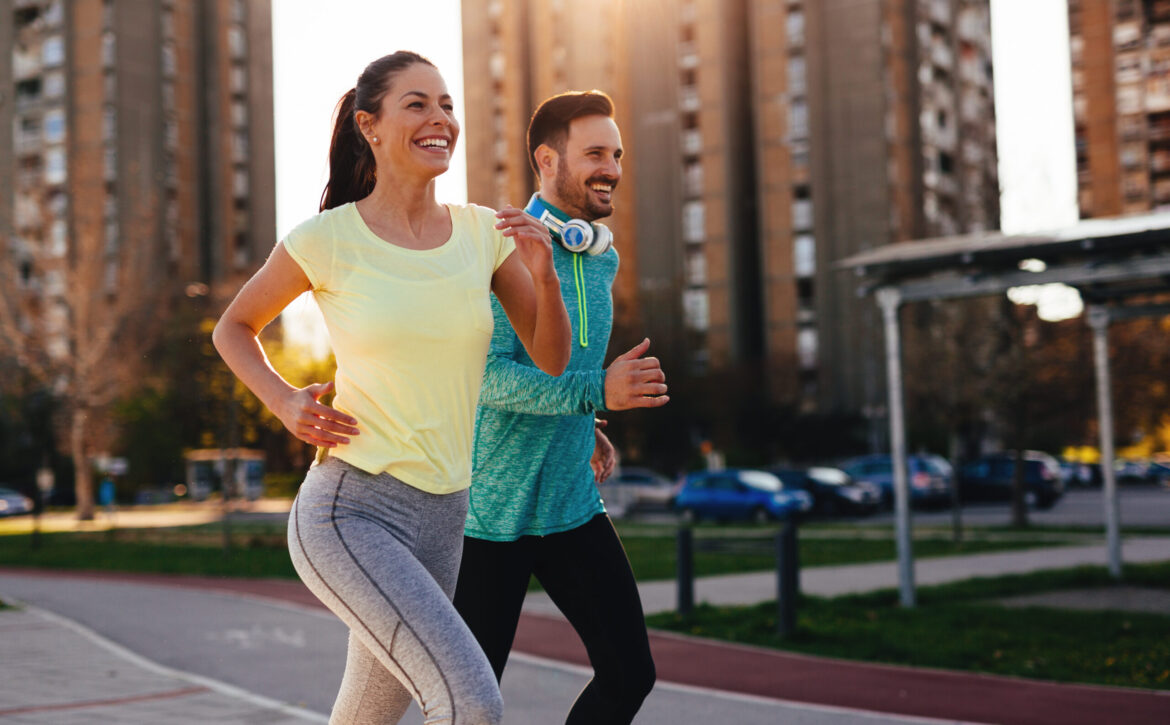 Young attractive couple running outside on sunny day