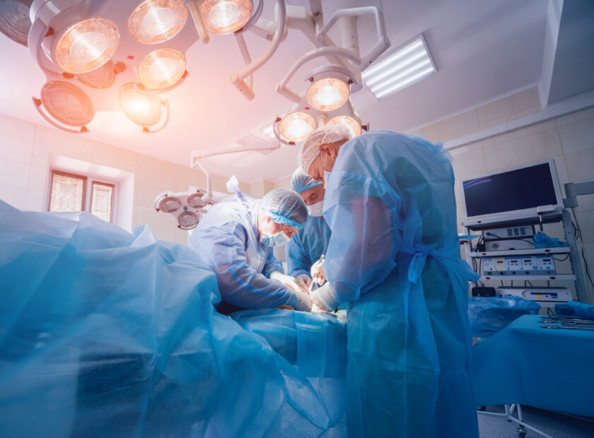 Process of trauma surgery operation. Group of surgeons in operating room with surgery equipment.