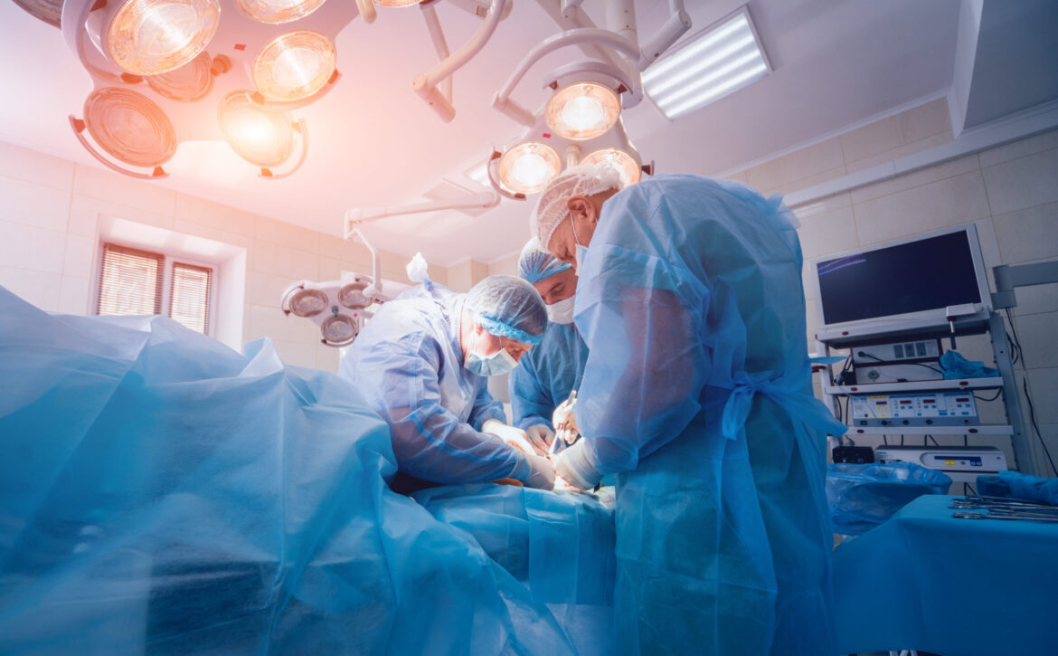 Process of trauma surgery operation. Group of surgeons in operating room with surgery equipment.